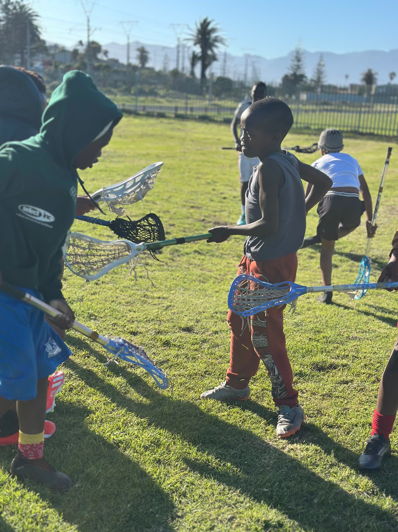 Players with sticks crossed at practice in Muizenberg